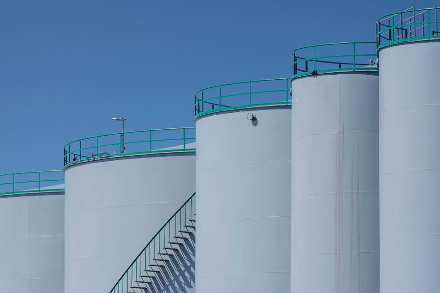 White industrial storage tanks against a blue sky